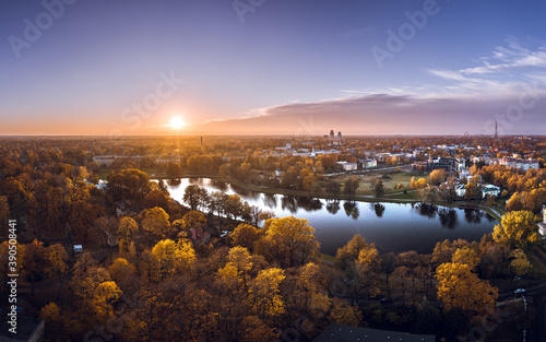 Aerial view of Riga city at colorful sunset. Beautiful architecture, impressive trees in autumn colors. Sustainable city.
