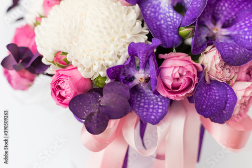 Flower arrangement in a gift box for a woman. Flowers bouquet with purple vanda orchids, white chrysanthemums, pink roses and eucalyptus. A festive concept. Place for text. white background.