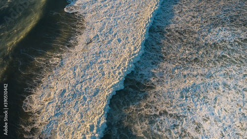 Foto Aerial top view of powerful ocean with crashing waves with plenty of white foam