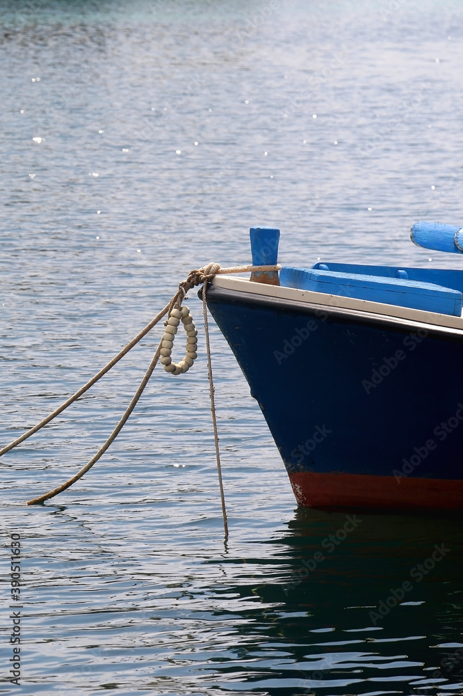 Small blue boat in the port. Selective focus, close-up.