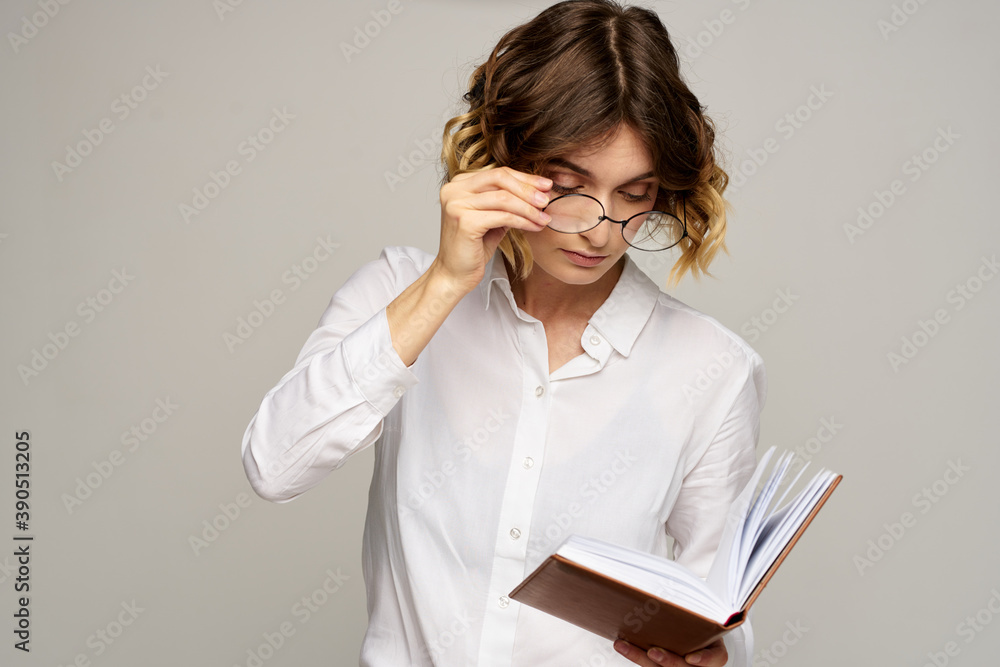 Business woman with notepad and glasses on a light background hairstyle success emotions Business woman with notepad and glasses on a light background hairstyle success emotions