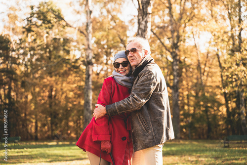Romantic happy senior couple hugging in beautiful autumn park.