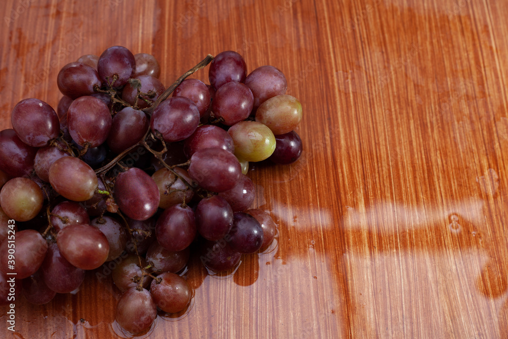 Red Globe grapes on top of wet wood with light reflection. Red Globe grapes on top of wet wood with light reflection.