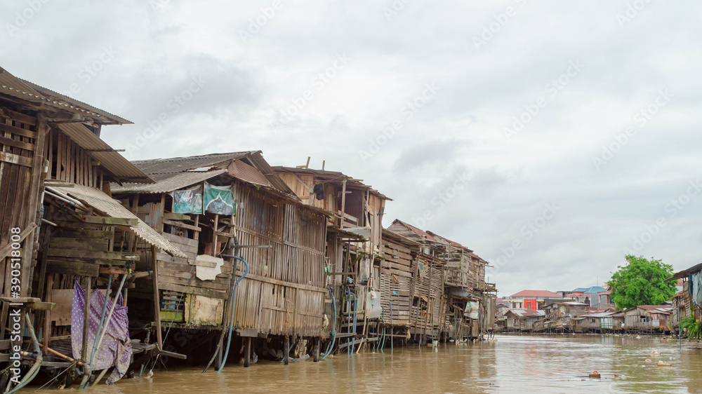 Wooden house on Karang Mumus Riverbank. Slum area on Karang Mumus river, Samarinda, Indonesia Wooden house on Karang Mumus Riverbank. Slum area on Karang Mumus river, Samarinda, Indonesia