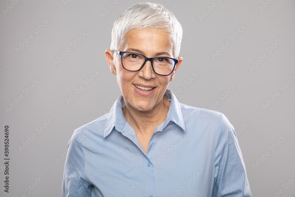 Smart senior businesswoman with glasses in a blue shirt and gray white hair and glasses