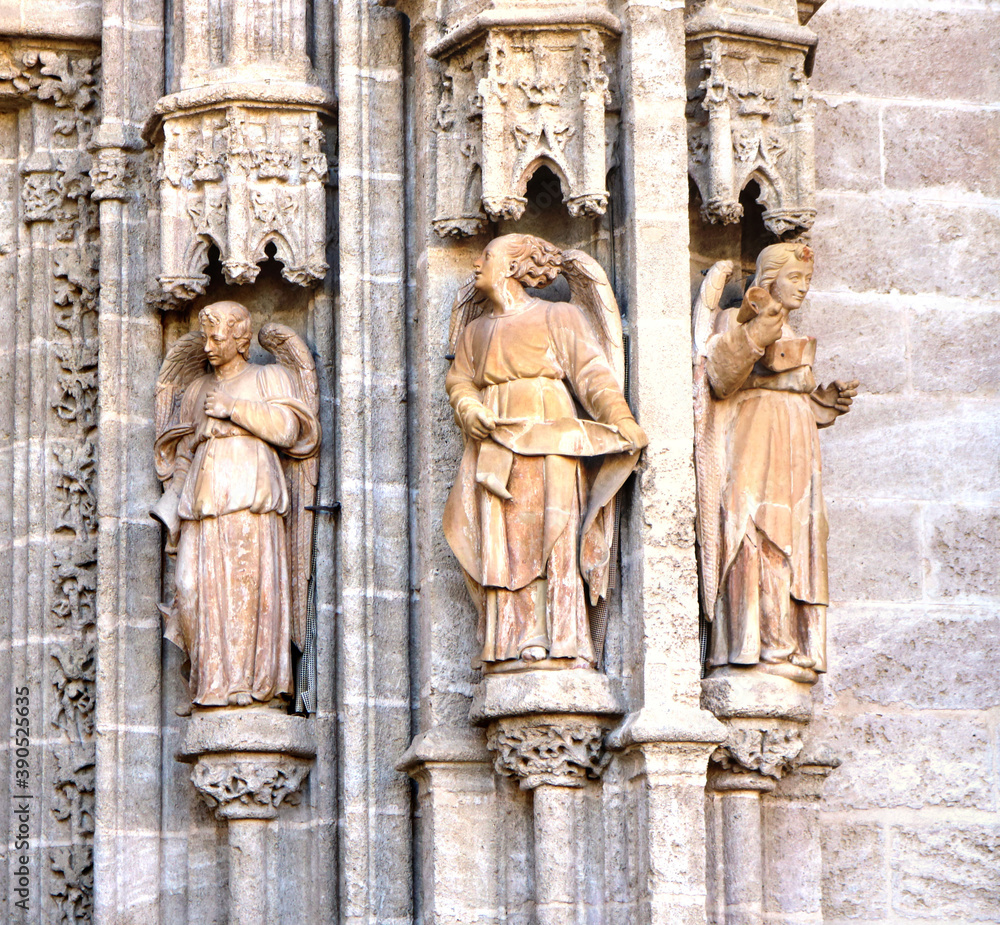 3 statures of angels with columns in the entrance of a cathedral ...