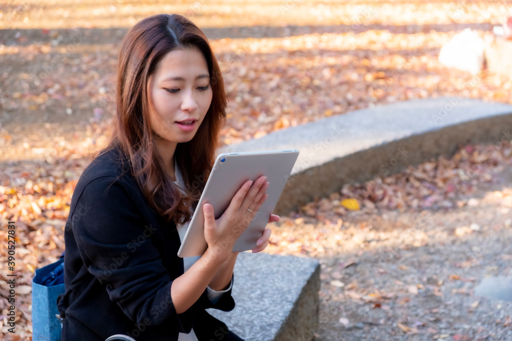 Obraz premium 【東京都】屋外でタブレットを操作する女性【2020年 紅葉】