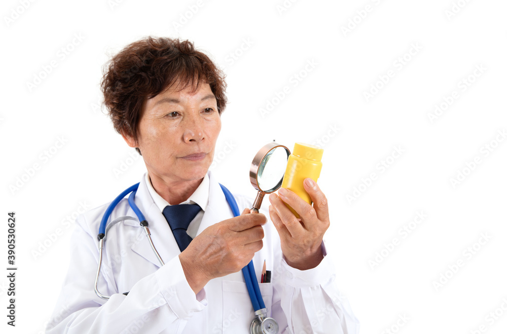 Chinese old doctor is looking at medicine bottle with magnifying glass in front of white background Chinese old doctor is looking at medicine bottle with magnifying glass in front of white background