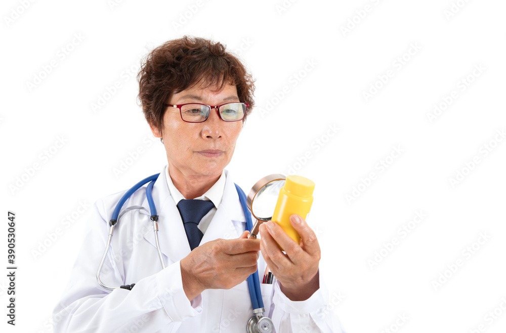 Chinese old doctor is looking at medicine bottle with magnifying glass in front of white background Chinese old doctor is looking at medicine bottle with magnifying glass in front of white background