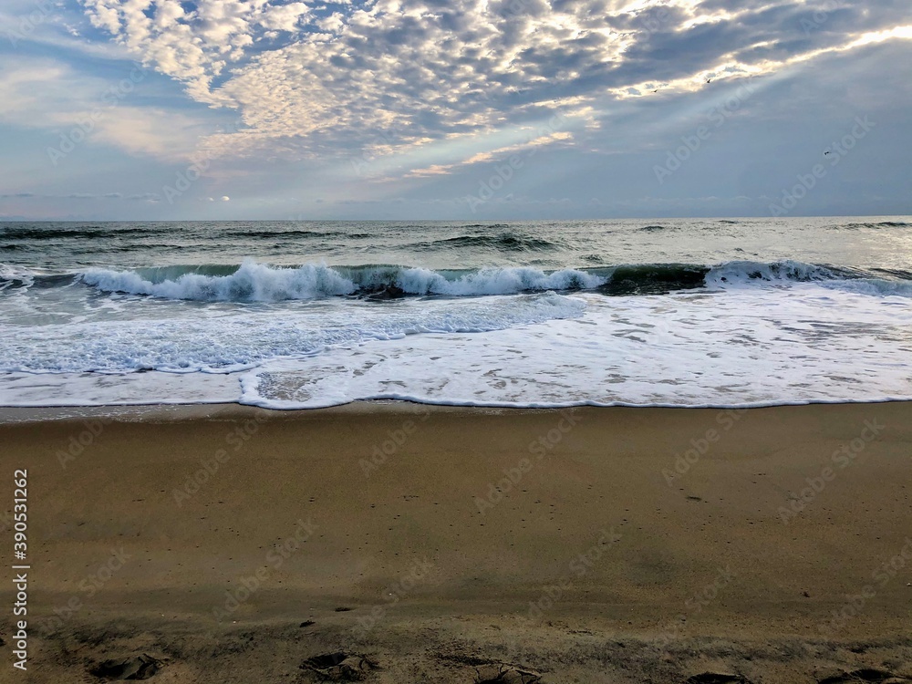 Cloudy day on the beach, waves crashing on the sand. Cloudy day on the beach, waves crashing on the sand.