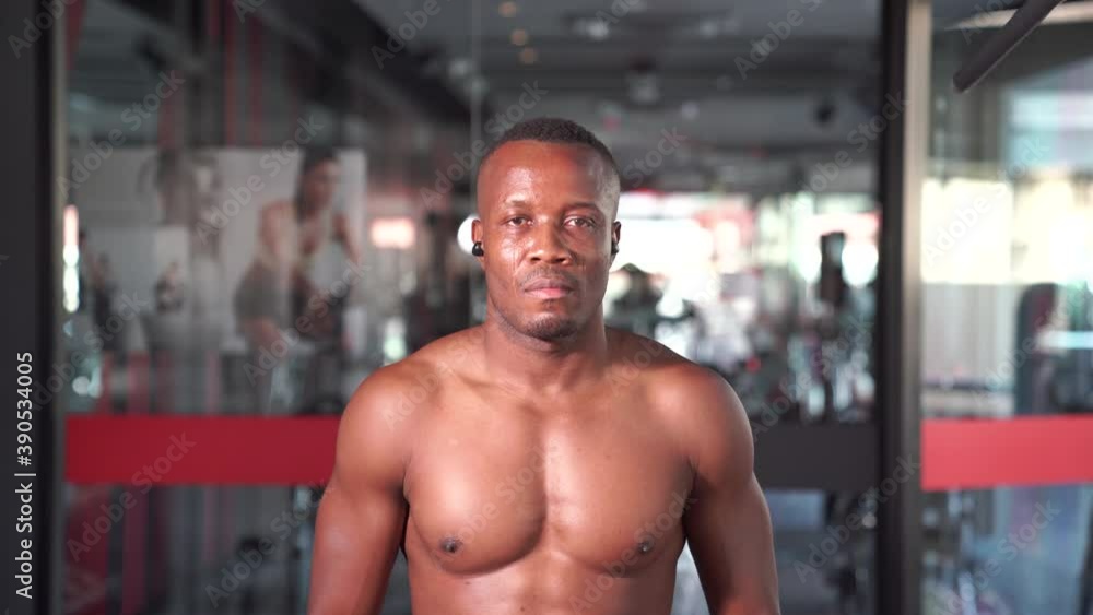 African man relaxing after workout looking straight to the camera at gym African man relaxing after workout looking straight to the camera at gym