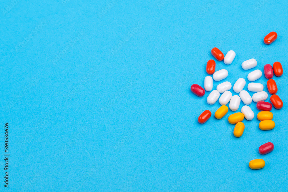 Scattered pills and vitamins on a blue background. Scattered pills and vitamins on a blue background.