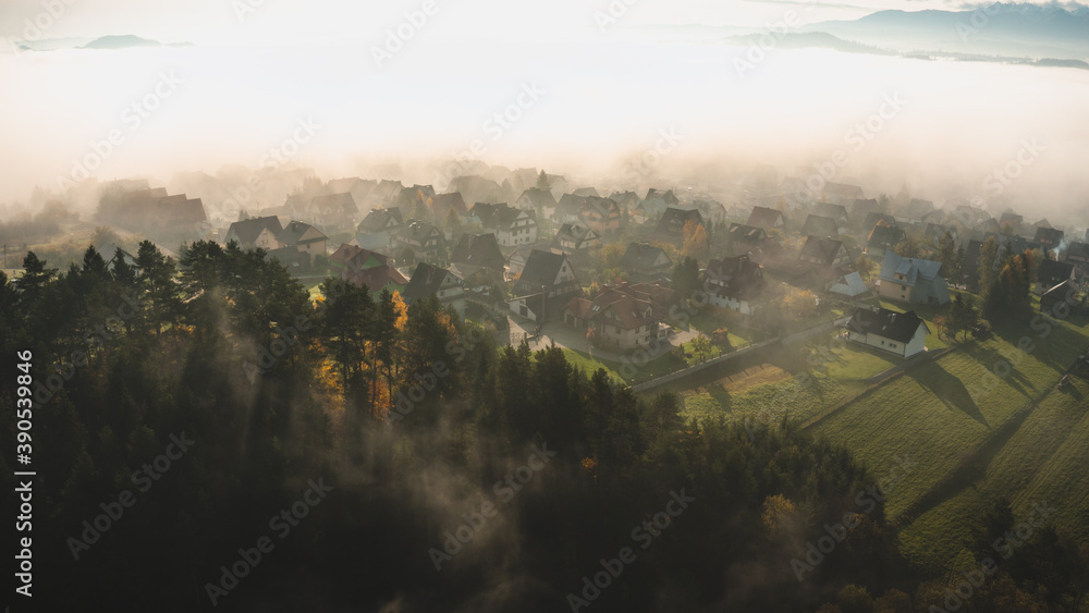 Mountain village in a early moorning with fog and autumn leaves