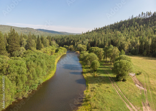 Drone over a river, country road and forest. Aerial amazing view of streams.