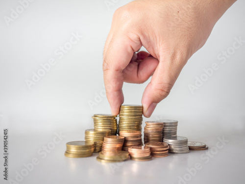 The hand was picking up the money that had been stacked up in layers. White background