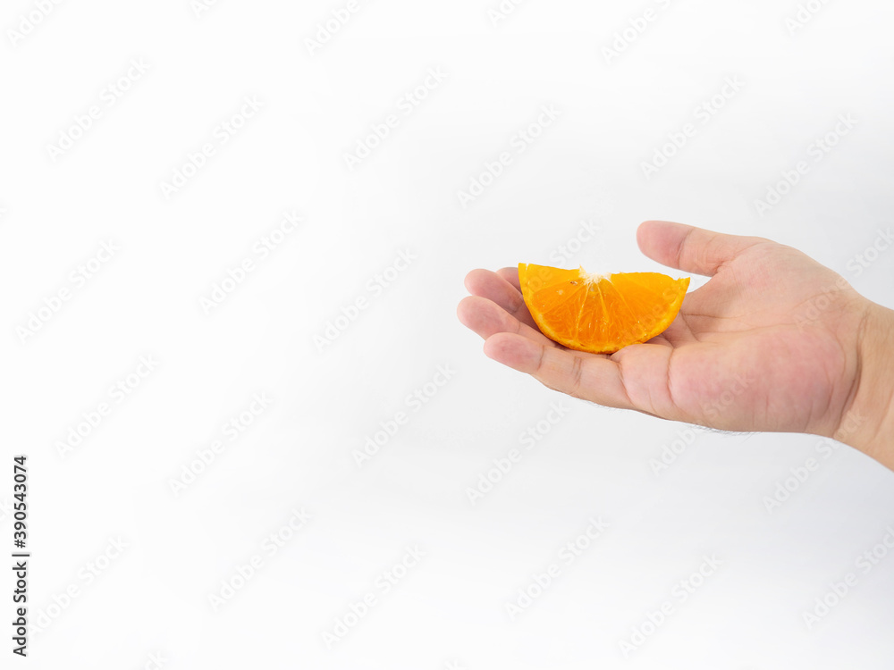 A man's hand holds an orange that has been turned into small halves. With fine stripes of orange pulp White background A man's hand holds an orange that has been turned into small halves. With fine stripes of orange pulp White background