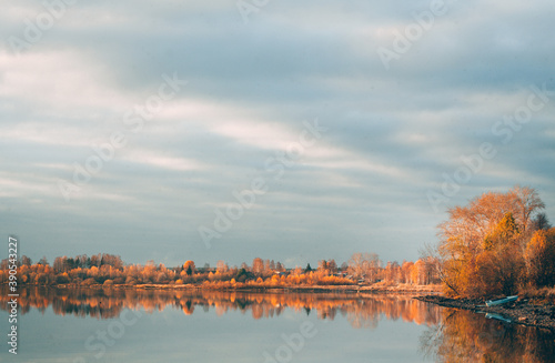 Colorful rural autumn landscape. Autumn forest by the water. The pond and the forest. Open landscape. Design for greeting cards