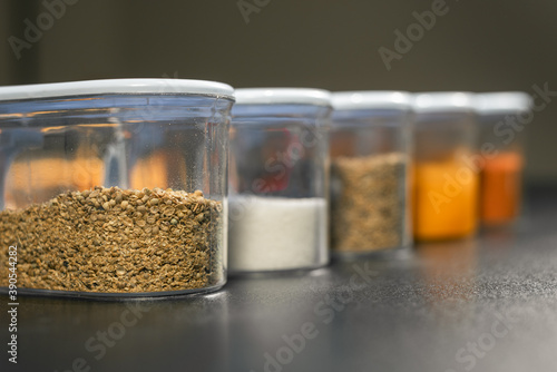 Coriander powder in focus in random spice Jars