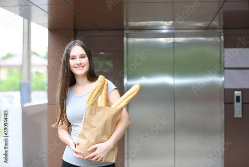 woman holding breads in paper bag