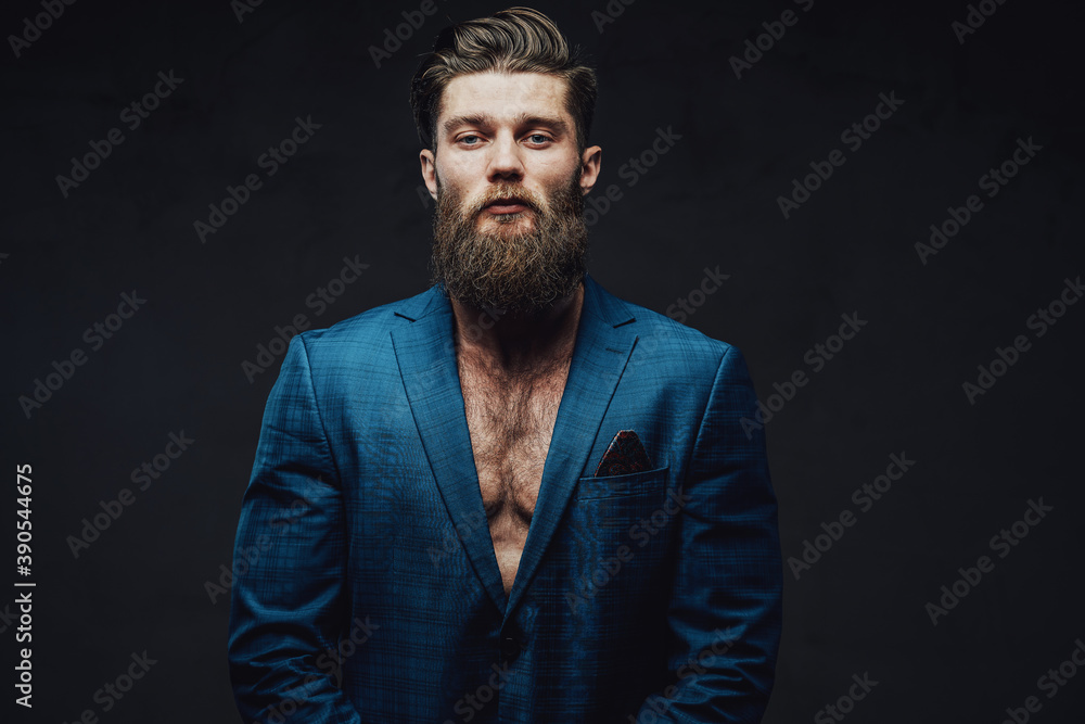 Obraz premium Bearded and mature businessman posing in blue suite with stylish haircut and serious face in dark background.