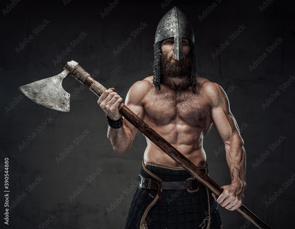 Strong and furious nord barbarian posing in dark studio background ...