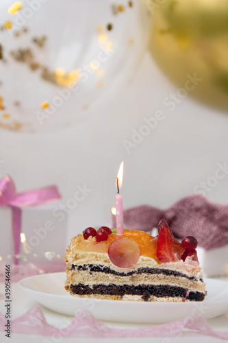 Slice of birthday cake with candle.