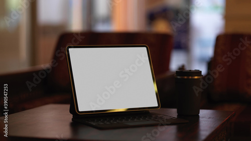 Mock up digital tablet with keyboard and coffee cup on coffee table