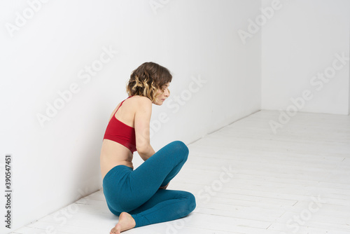 woman doing yoga full length indoors blue leggings red tank top