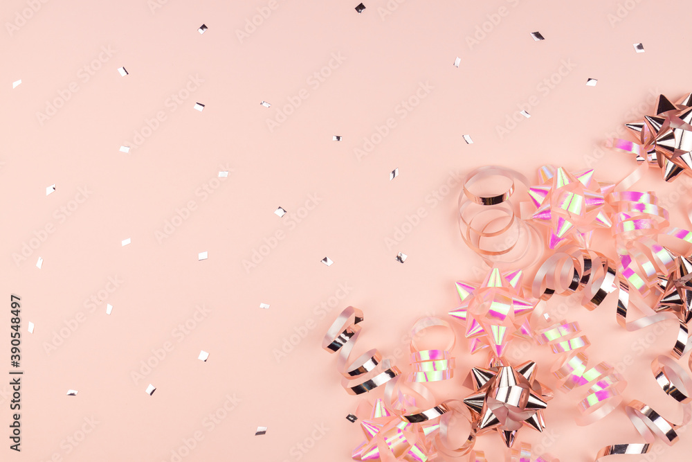 Christmas or New Year composition with pink sparkling ribbons and gift bows decorations on pink background. Flat lay and copy space Christmas or New Year composition with pink sparkling ribbons and gift bows decorations on pink background. Flat lay and copy space