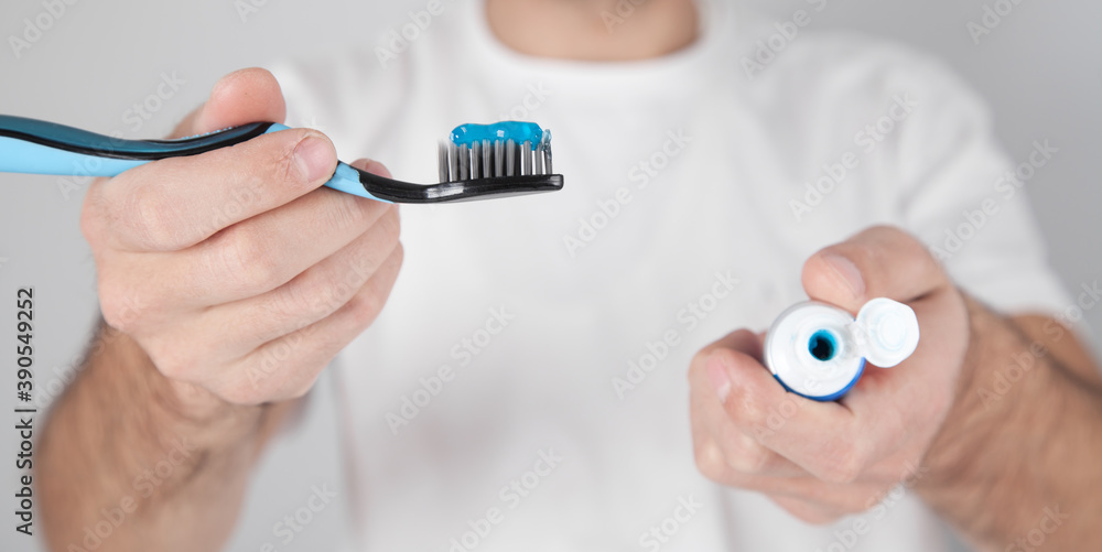 Man holding blue toothpaste and toothbrush. Man holding blue toothpaste and toothbrush.