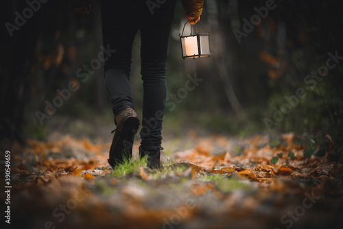 Fototapeta Man walking with a lantern in a woods
