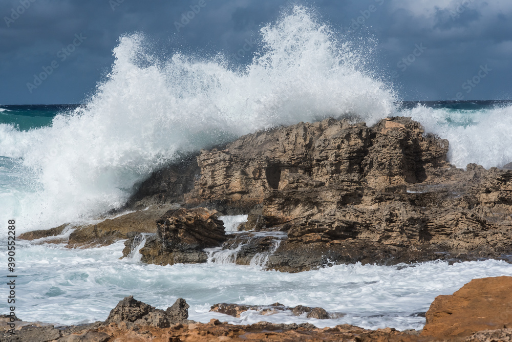 Seascape. Rough sea day with the waves crashing violently against the rocks on the shore.