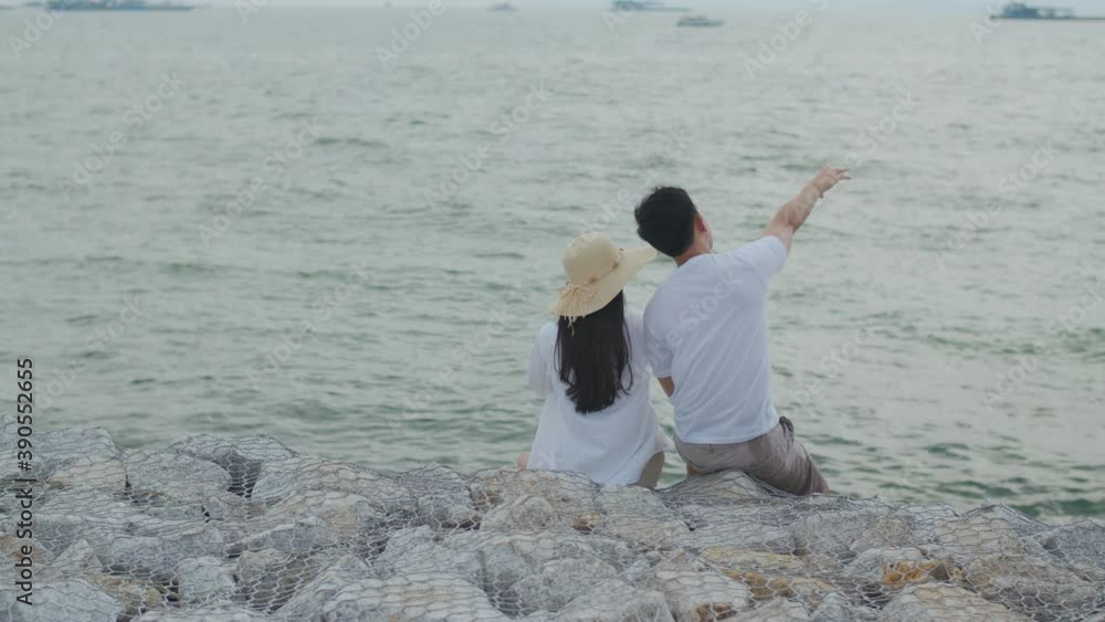 Man and woman couple enjoying on holiday summer happy talking and laughing and look at the view on the beach during sunset. Man and woman couple enjoying on holiday summer happy talking and laughing and look at the view on the beach during sunset.