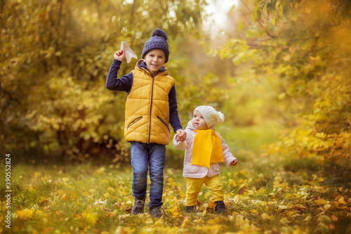 boy and girl brother and sister walking in the Park in autumn, laughing, playing, October, yellow leaves, Golden autumn, happy childhood