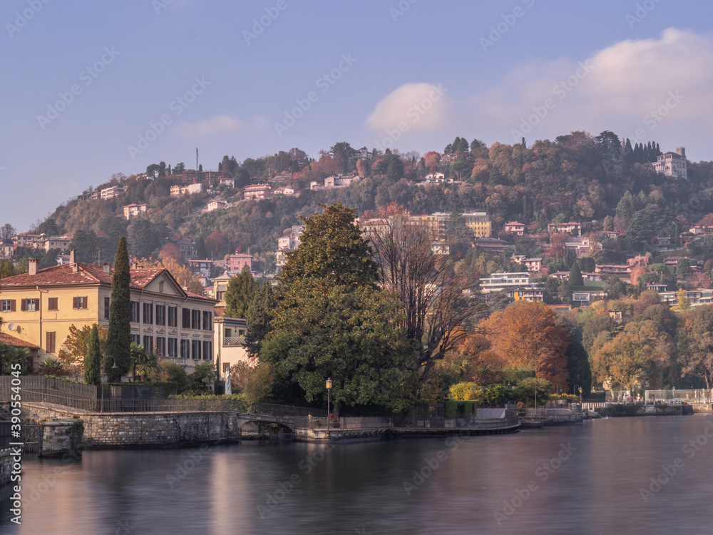 Obraz premium Suggestive pedestrian path runs along the lake in fall season.Autumn landscape on Como lake, Lombardy, Italy.