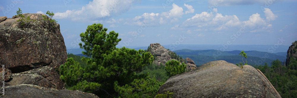 View from the top of the cliff. Rocks and blue sky with clouds. Mountain landscape. Stolby National Park in Krasnoyarsk. The nature of Siberia. Russia. Rock.