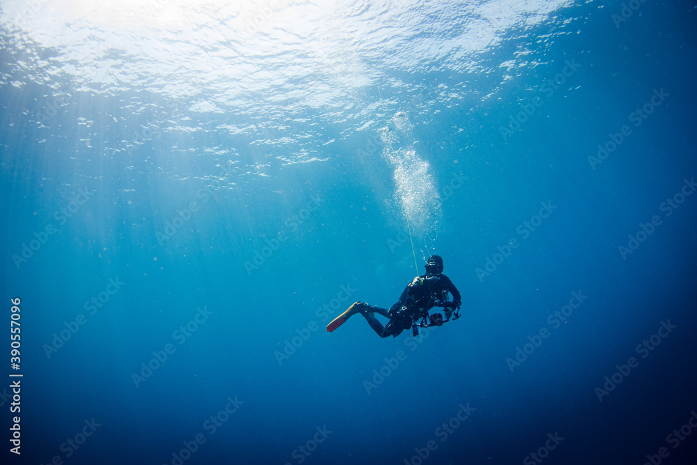 Scuba Diver underwater of the big blue sea making safety stop after a dive.
