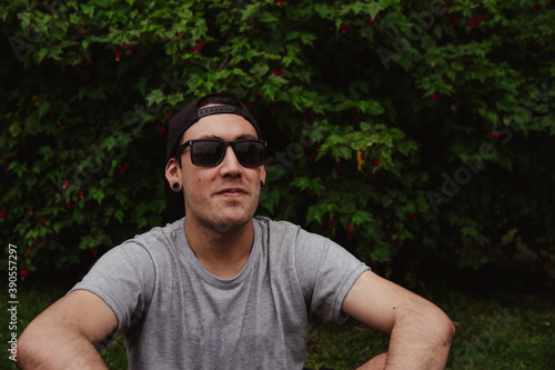 Handsome young man dressed in casual clothes outdoors, sunglasses, copy space, social media, smile, happiness, recreation concept, man advertising
