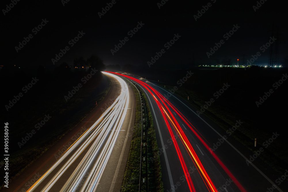 Vehicle car light trails on highway in red and white color. Trafic at night, long exposure