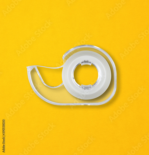 Scotch tape dispenser isolated on yellow background photo