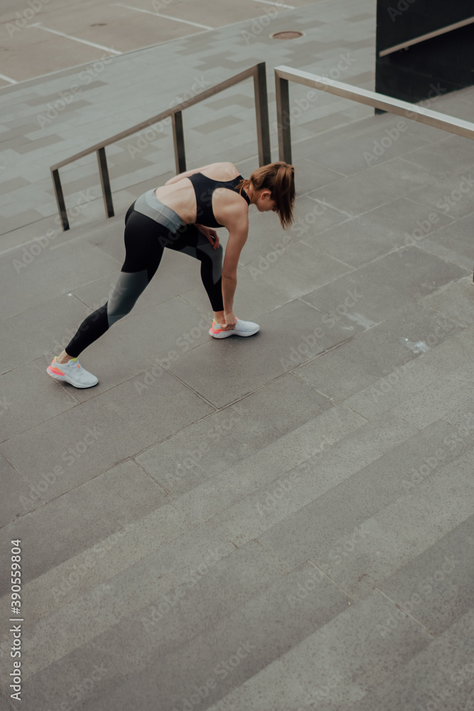 Obraz premium A young Caucasian girl, trains on the street, in sportswear, in the city.
