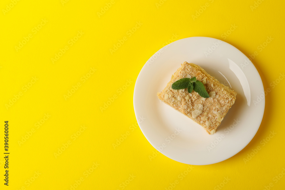 Plate with delicious Napoleon cake on yellow background Plate with delicious Napoleon cake on yellow background