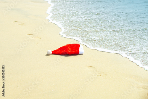 Santa Hat on the sand. Christmas and New Year's vacation in hot countries. Tropical Christmas. New year vacation on tropical beach.