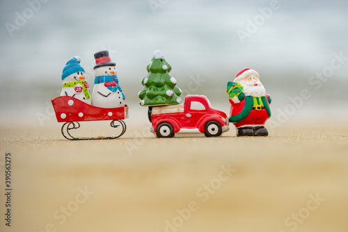 Toy Santa Claus snowman on sea, concept for travel destinations in hot tourist countries.