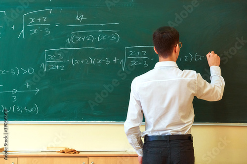 A student used white chalk to write mathematical formulas on the blackboard