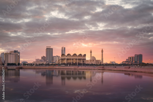 Bahrain National Library or Isa Cultural Centre and Al Fateh Mosque with beautiful reflection and clouds in Manama, Bahrain.