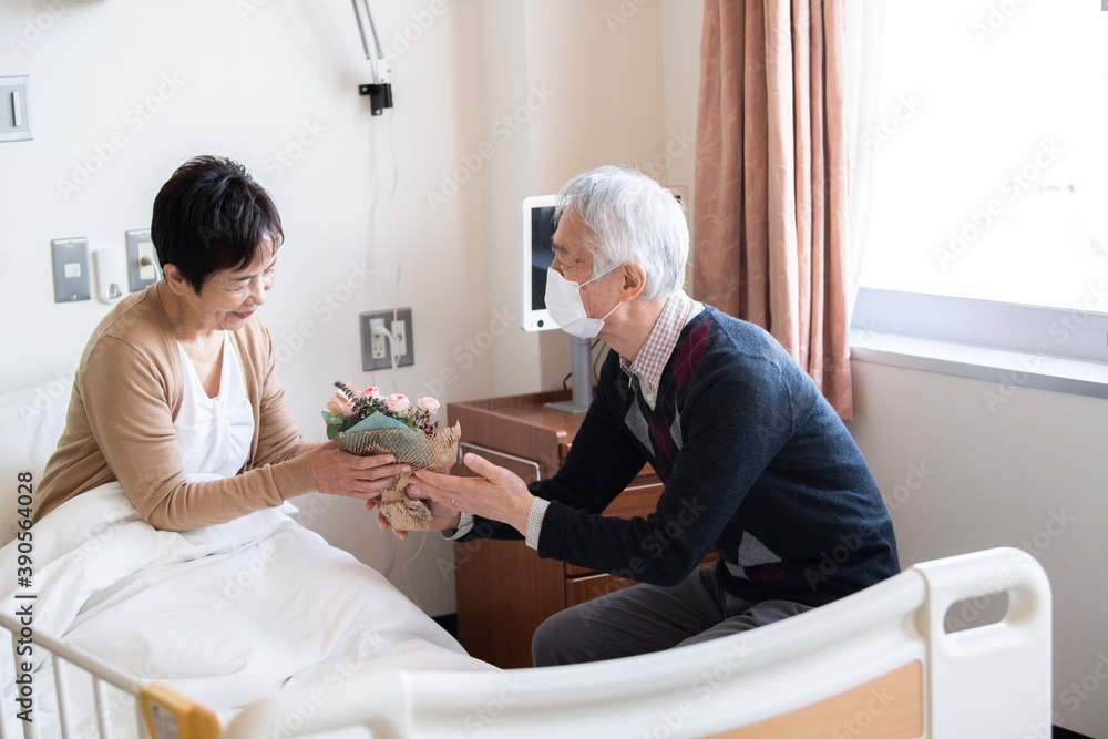 Obraz premium 入院中の妻に花をプレゼントする夫
