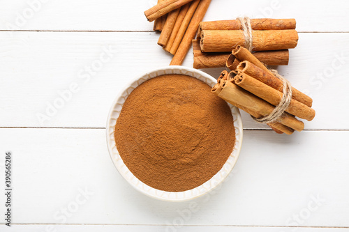Fototapeta Naklejka Na Ścianę i Meble -  Bowl with cinnamon powder and sticks on table