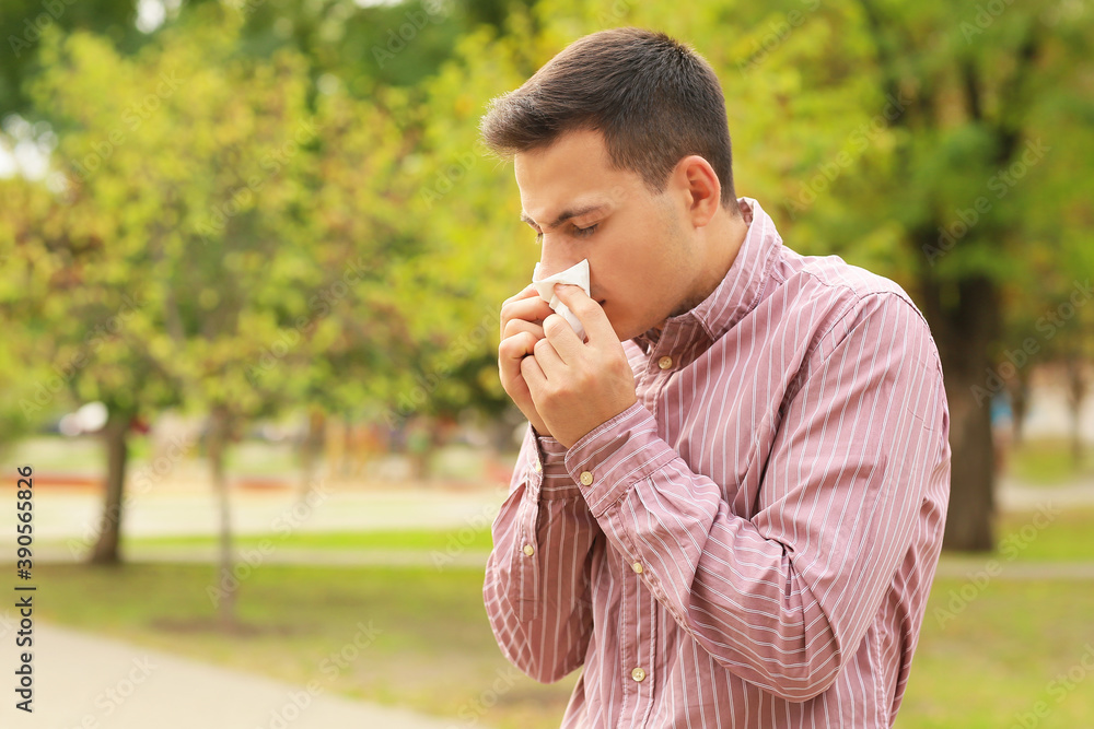 Fototapeta premium Young man suffering from allergy outdoors