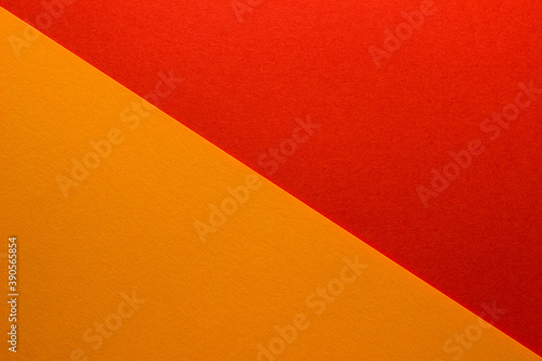 Background of red and orange paper divided diagonally. Sheets of blank orange and red paper with fine texture, close up.